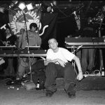 NEW YORK — MARCH 1999:  Rapper Eminem, seated, and unidentified rappers and DJs on turntables in background, perform at Tramps in March 1999 in New York City, New York. (Photo by Catherine McGann/Getty Images)