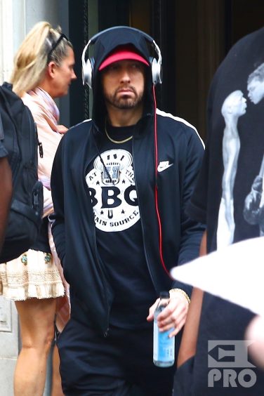New York, NY - *EXCLUSIVE* - Eminem quickly heads to his car after leaving his hotel. Eminem doesn't have the time to stop and talk to fans as he waves instead and hops into his ride.