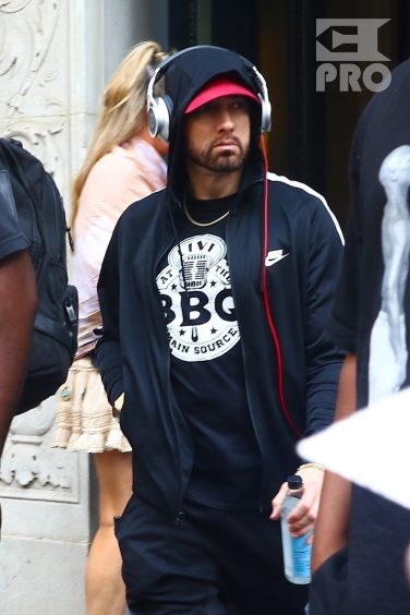 New York, NY - *EXCLUSIVE* - Eminem quickly heads to his car after leaving his hotel. Eminem doesn't have the time to stop and talk to fans as he waves instead and hops into his ride.