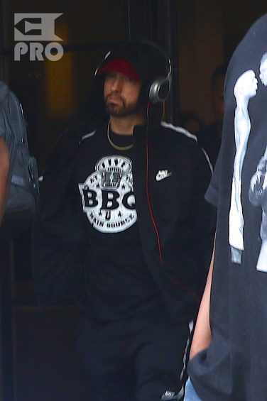 New York, NY - *EXCLUSIVE* - Eminem quickly heads to his car after leaving his hotel. Eminem doesn't have the time to stop and talk to fans as he waves instead and hops into his ride.