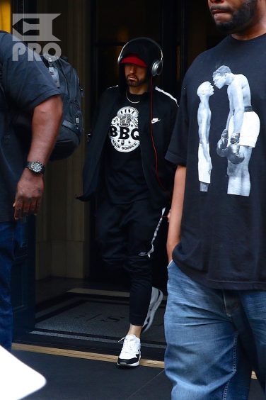 New York, NY - *EXCLUSIVE* - Eminem quickly heads to his car after leaving his hotel. Eminem doesn't have the time to stop and talk to fans as he waves instead and hops into his ride.