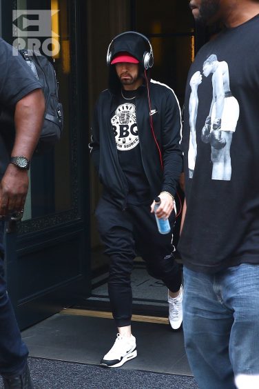 New York, NY - *EXCLUSIVE* - Eminem quickly heads to his car after leaving his hotel. Eminem doesn't have the time to stop and talk to fans as he waves instead and hops into his ride.