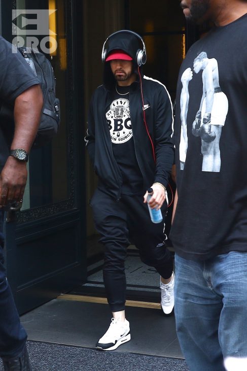New York, NY - *EXCLUSIVE* - Eminem quickly heads to his car after leaving his hotel. Eminem doesn't have the time to stop and talk to fans as he waves instead and hops into his ride.