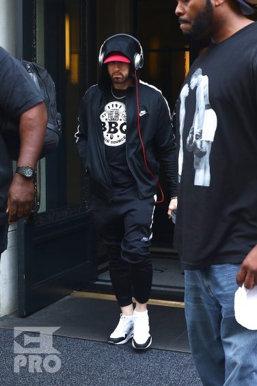 New York, NY - *EXCLUSIVE* - Eminem quickly heads to his car after leaving his hotel. Eminem doesn't have the time to stop and talk to fans as he waves instead and hops into his ride.
