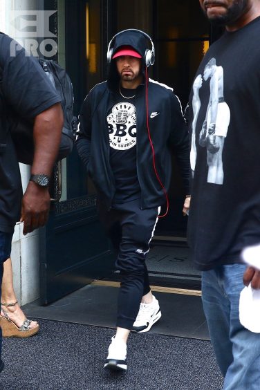 New York, NY - *EXCLUSIVE* - Eminem quickly heads to his car after leaving his hotel. Eminem doesn't have the time to stop and talk to fans as he waves instead and hops into his ride.