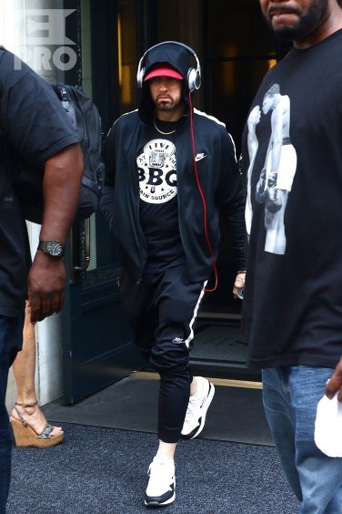 New York, NY - *EXCLUSIVE* - Eminem quickly heads to his car after leaving his hotel. Eminem doesn't have the time to stop and talk to fans as he waves instead and hops into his ride.