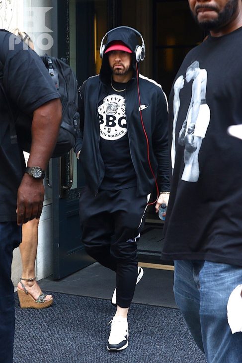 New York, NY - *EXCLUSIVE* - Eminem quickly heads to his car after leaving his hotel. Eminem doesn't have the time to stop and talk to fans as he waves instead and hops into his ride.