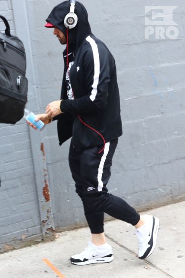 New York, NY - *EXCLUSIVE* - Eminem quickly heads to his car after leaving his hotel. Eminem doesn't have the time to stop and talk to fans as he waves instead and hops into his ride.