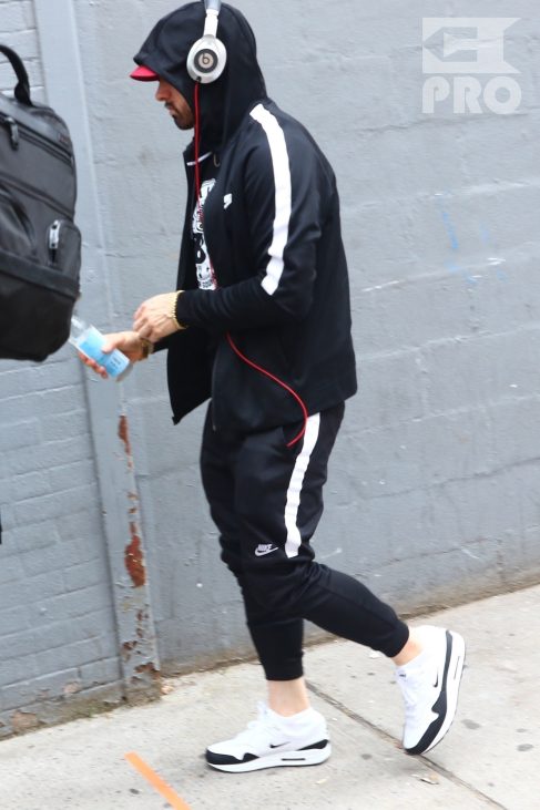 New York, NY - *EXCLUSIVE* - Eminem quickly heads to his car after leaving his hotel. Eminem doesn't have the time to stop and talk to fans as he waves instead and hops into his ride.