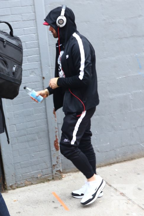 New York, NY - *EXCLUSIVE* - Eminem quickly heads to his car after leaving his hotel. Eminem doesn't have the time to stop and talk to fans as he waves instead and hops into his ride.