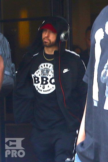 New York, NY - *EXCLUSIVE* - Eminem quickly heads to his car after leaving his hotel. Eminem doesn't have the time to stop and talk to fans as he waves instead and hops into his ride.
