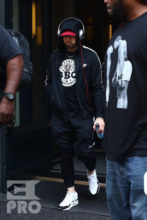 New York, NY - *EXCLUSIVE* - Eminem quickly heads to his car after leaving his hotel. Eminem doesn't have the time to stop and talk to fans as he waves instead and hops into his ride.