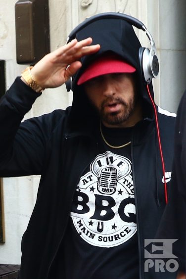 New York, NY - *EXCLUSIVE* - Eminem quickly heads to his car after leaving his hotel. Eminem doesn't have the time to stop and talk to fans as he waves instead and hops into his ride.